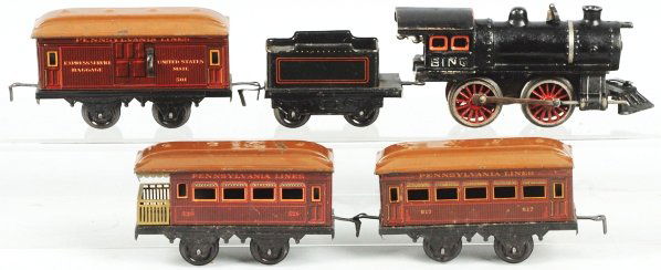 Bing O-Gauge Wind-Up Passenger Train Set.: German. Includes cast clockwork steam type engine with matching tender and three Pennsylvania passenger cars. Includes original box with nice paper label. Box has some staining and wear. Condition (Ex