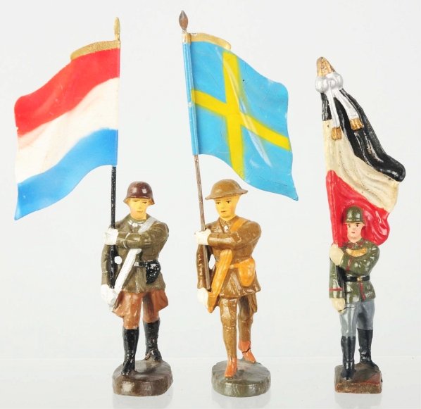 Elastolin & Lineol Flagbearers.: Lot of three includes Elastolin Luxembourg, Lineol small-size German, and Swedish carried by a US soldier. Condition (Very Good - Excellent).