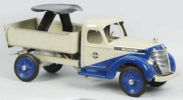 Pressed Steel Buddy L Int'l Ride-On Dump Truck.: American. This is a scarce truck with hydraulic dump. Includes seat and attached handle. Completely restored with new decals. Condition (Restored). Size 27" L.