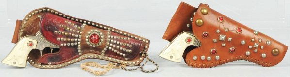 Lot of 2: Texan Cast Iron Cap Guns & Holsters.: Both in working condition. Holsters have some wear. Condition (Very Good - Excellent). Size Largest: 9" L.