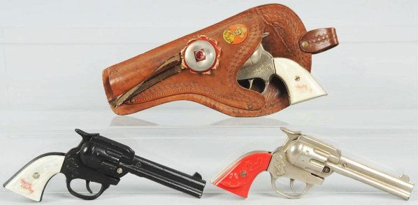 Lot of 3: Gene Autry Cap Guns with 1 Holster.: The nickel finish with white grips and the one with orange grips are dummies. Includes nice Keyston holster. Condition (Excellent). Size Each: 8 - 1/2" L.