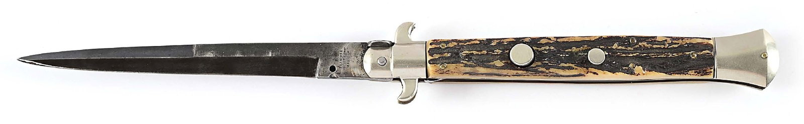 EARLY LARGE MANIAGO AUTOMATIC KNIFE: A massive automatic knife with a 6" bayonet style blade with false top edge marked "PREMIATA / SOCIETA COOP / MANIAGO" on obverse ricasso. Blade exhibits a dark gray patina with scattered blemishes. S