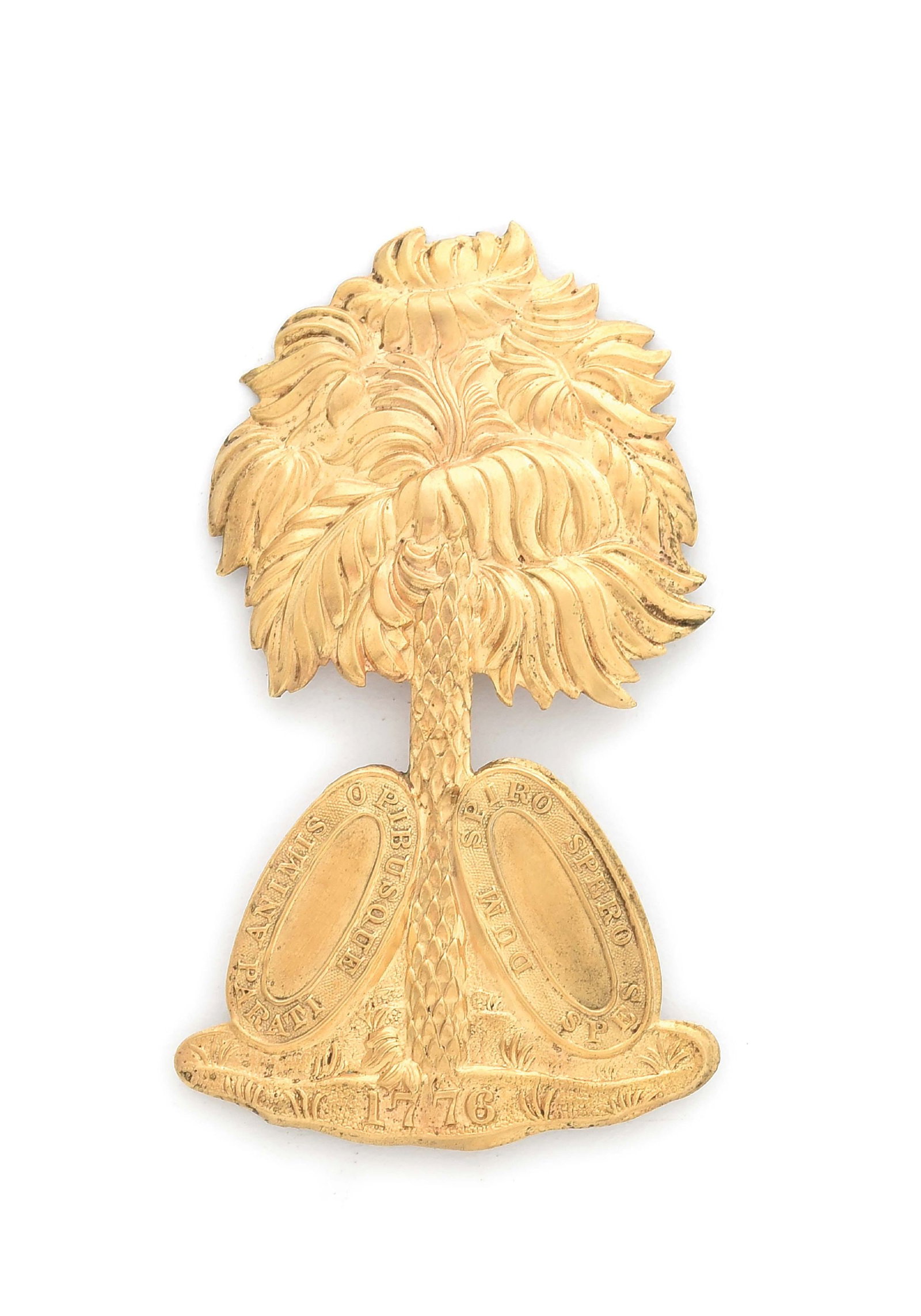 PRE-CIVIL WAR GOLD PLATED SOUTH CAROLINA HAT INSIGNIA.: Rare, gold-plated pre-war South Carolina hat pin in the form of a palmetto tree flanked by the ellipses of the state seal and the date “1776.” Stamped brass with 4 soldered brass wire atta