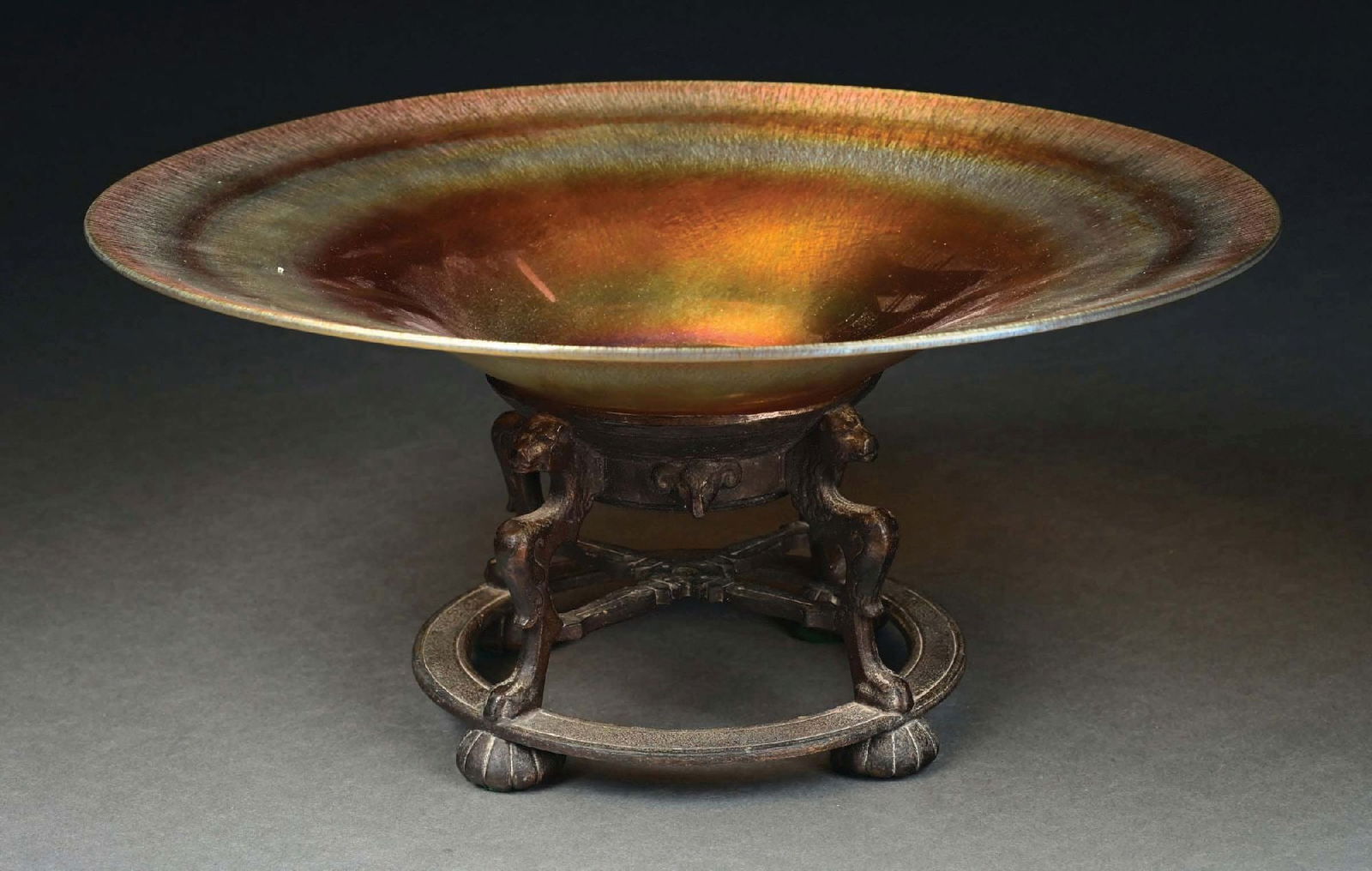 LUSTRE ART TAZZA W/ BRONZE BASE ATTRIBUTED TO OSCAR BACH: A beautiful and large tazza by Lustre Art, sitting on a lovely bronze base attributed to Oscar Bach. The 15" diameter bowl is composed of gold art glass with iridescence throughout. There is a beautif