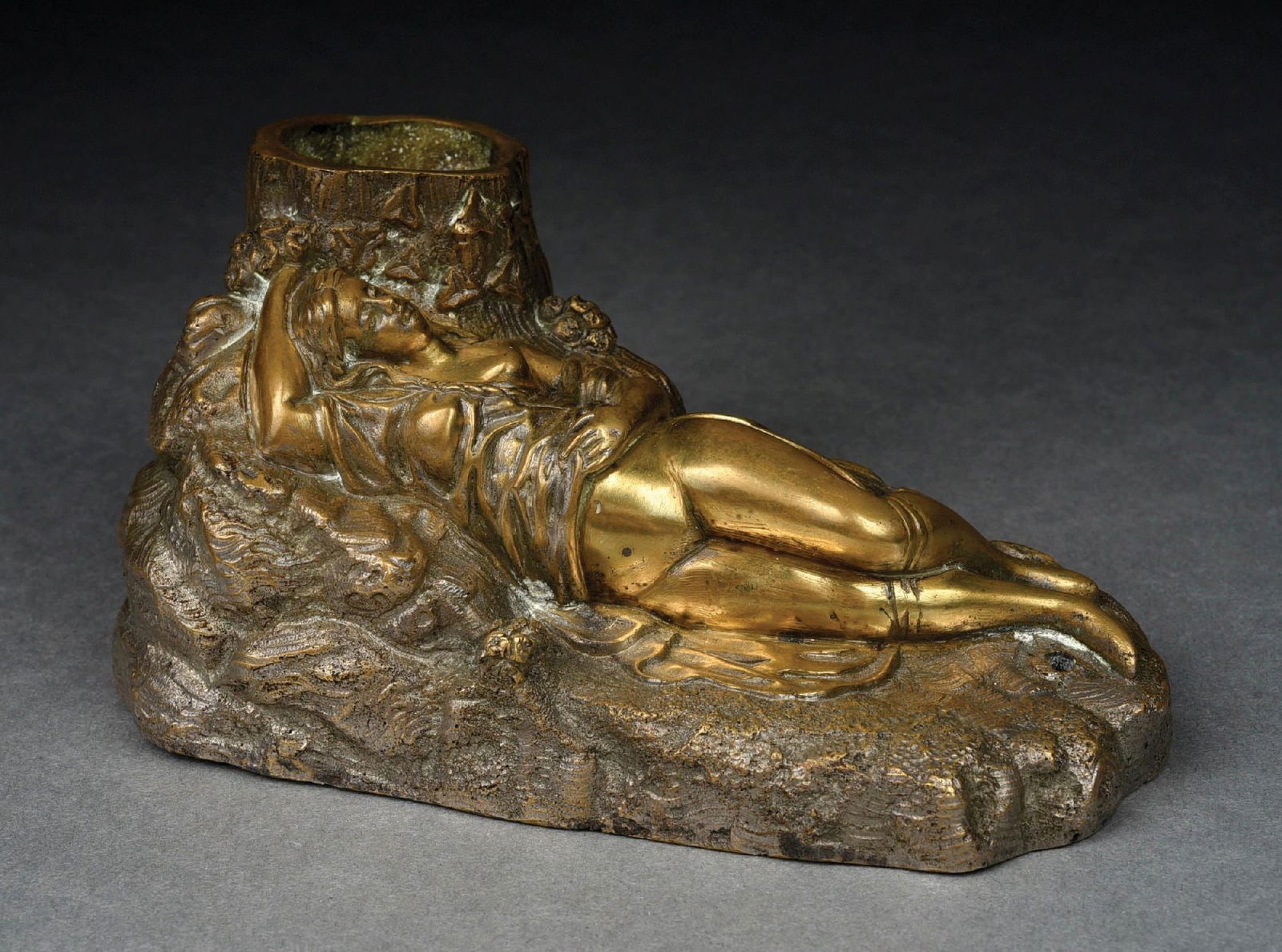 EROTIC GILTED BRONZE MATCH HOLDER: Reclining partially nude woman lying besides tree trunk. Nice detail, heavy bronze. No damage or repairs. Condition: (Excellent) Dimensions: 7" x 3 - 1/2" x 3 - 1/4".