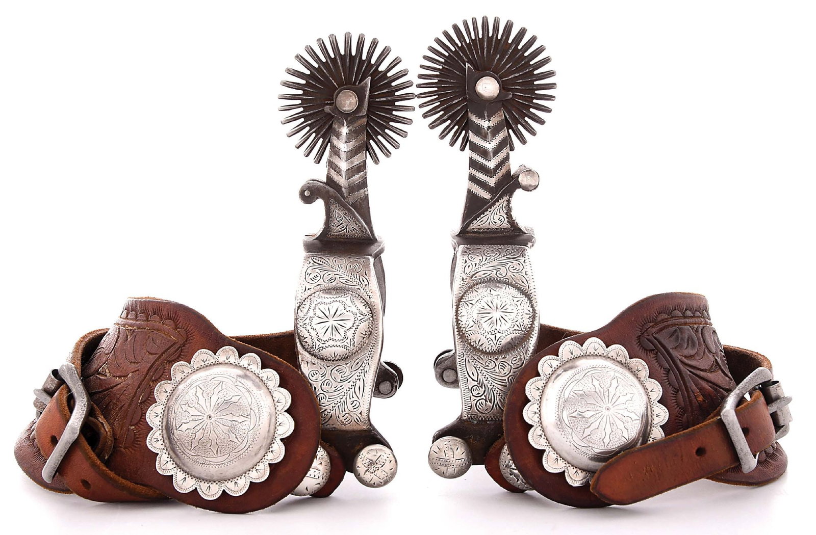 (TOM) QUALEY MAKER-MARKED, GRANGEVILLE, IDAHO SPURS: Designed with short split Cheyenne heelbands, 1 1/8" band, 2 1/4" shank, 2" rowels, inlaid stripes and engraved domed buttons affixed to two-piece floral carved, russet leathers adorned with domed and