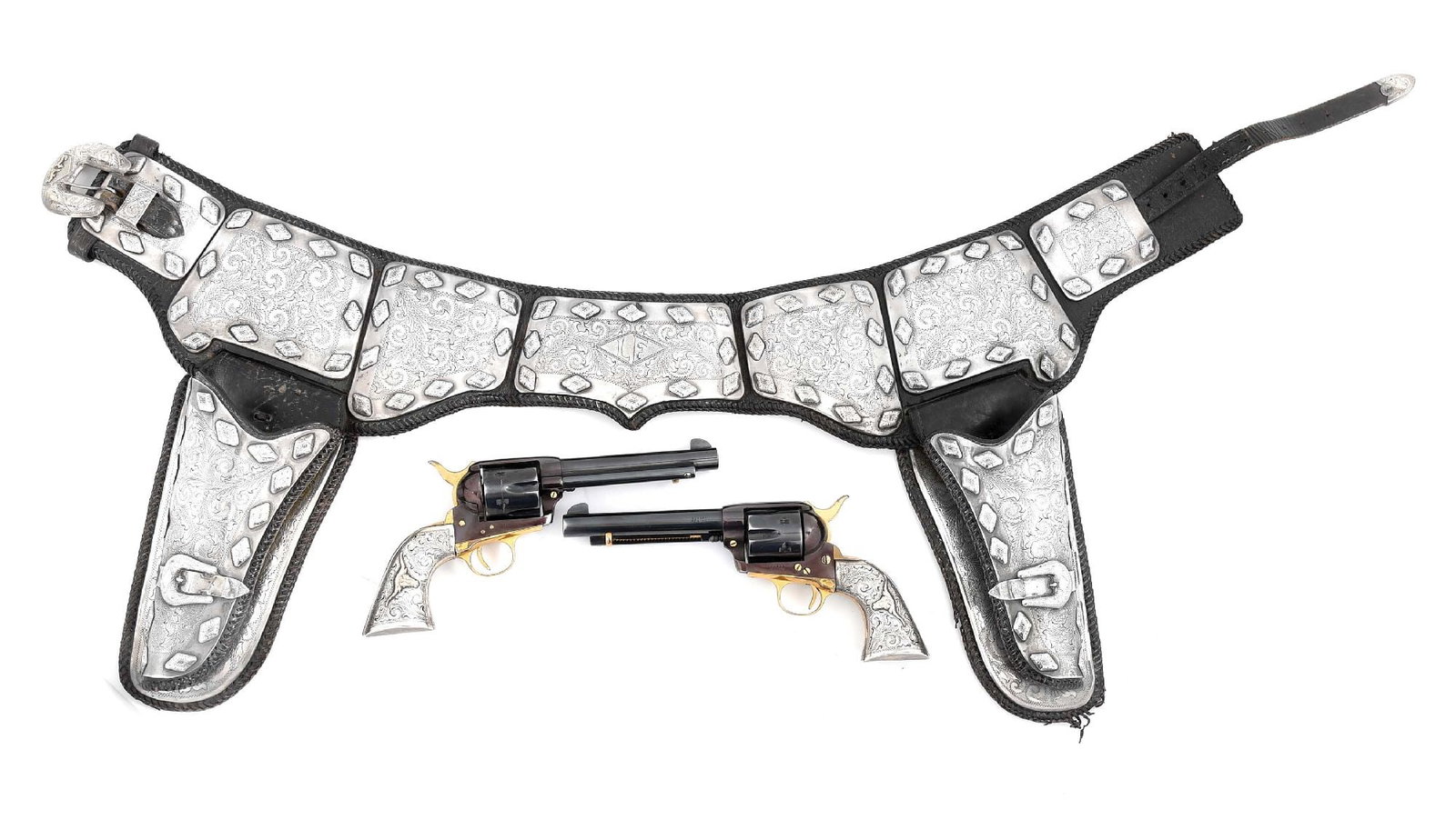 LEFTY FRIZZELL'S SILVER MOUNTED PARADE SET: Lefty Frizzell's silver mounted gun belt, guns and spurs. Ornate, black silver mounted double gun rig with a pair of Great Western Single Action revolvers sporting engraved silver grips with gold long