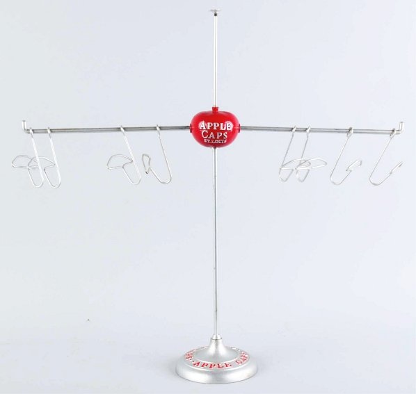 Apple Caps Store Display.: Circa 1920s to 1930s. Repainted apple and base. Retains original cap hooks for display. The display pedestal mount at the top is broken and missing. Condition (Excellent). Size 29" T.