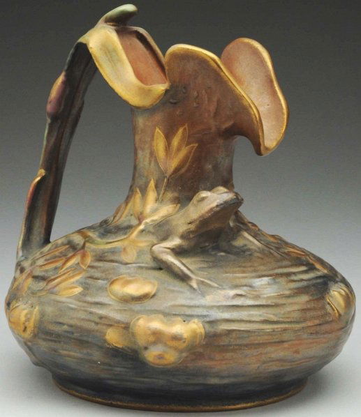 Amphora Frog Pitcher.: 6 - 1/2" T. Stylized pond scene with frog in pond. Gold highlights. Amphora oval mark. (Mint).