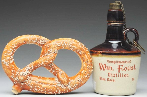 Lot of 2: Advertising Pieces.: Largest: 5 - 3/4" T. Includes one stoneware jug marked "Glen Rock Pennsylvania William Foust Distiller" and one pottery pretzel flask. (Excellent).