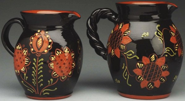 Pair of Lester Breininger Water Pitchers.: 8 - 1/4" T. Includes one with sunflower and one with sunflowers and tulips. Both pieces retain their original handles. (Excellent).