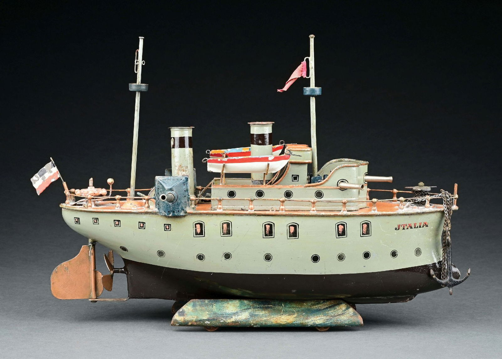 MARKLIN CAT. REF. 1087 "JTALIA" GUNBOAT W/ CLOCKWORK POWER: C. 1904-1906. CONDITION: Stern mast is replaced, incorrect flag, retains original life boats, guns, key stand, and anchor. Some cleaning residue on deck; otherwise, excellent to near mint. ILLUSTRATED