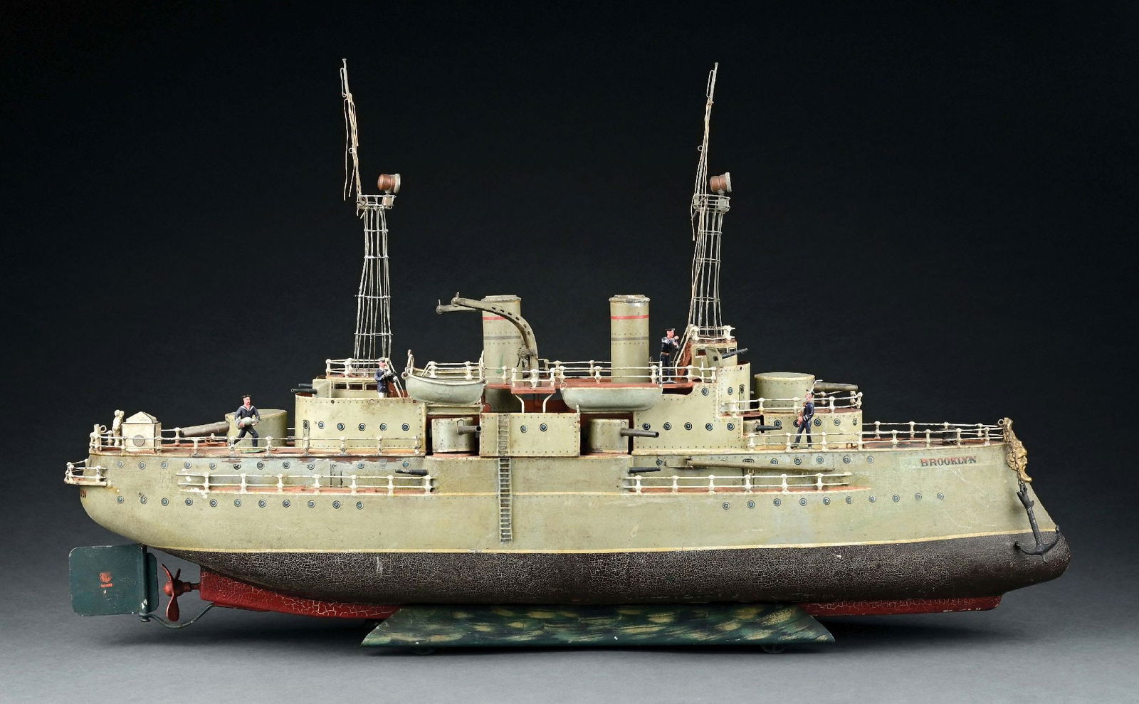 MARKLIN CAT. REF. 5130 "BROOKLYN" BATTLESHIP W/ LIVE STEAM PROPULSION: C. 1915. This boat retains all of its original parts. This boat has a special feature of having lattice tape mast for the American market. CONDITION: It is in as-found condition, with paint crazing mo