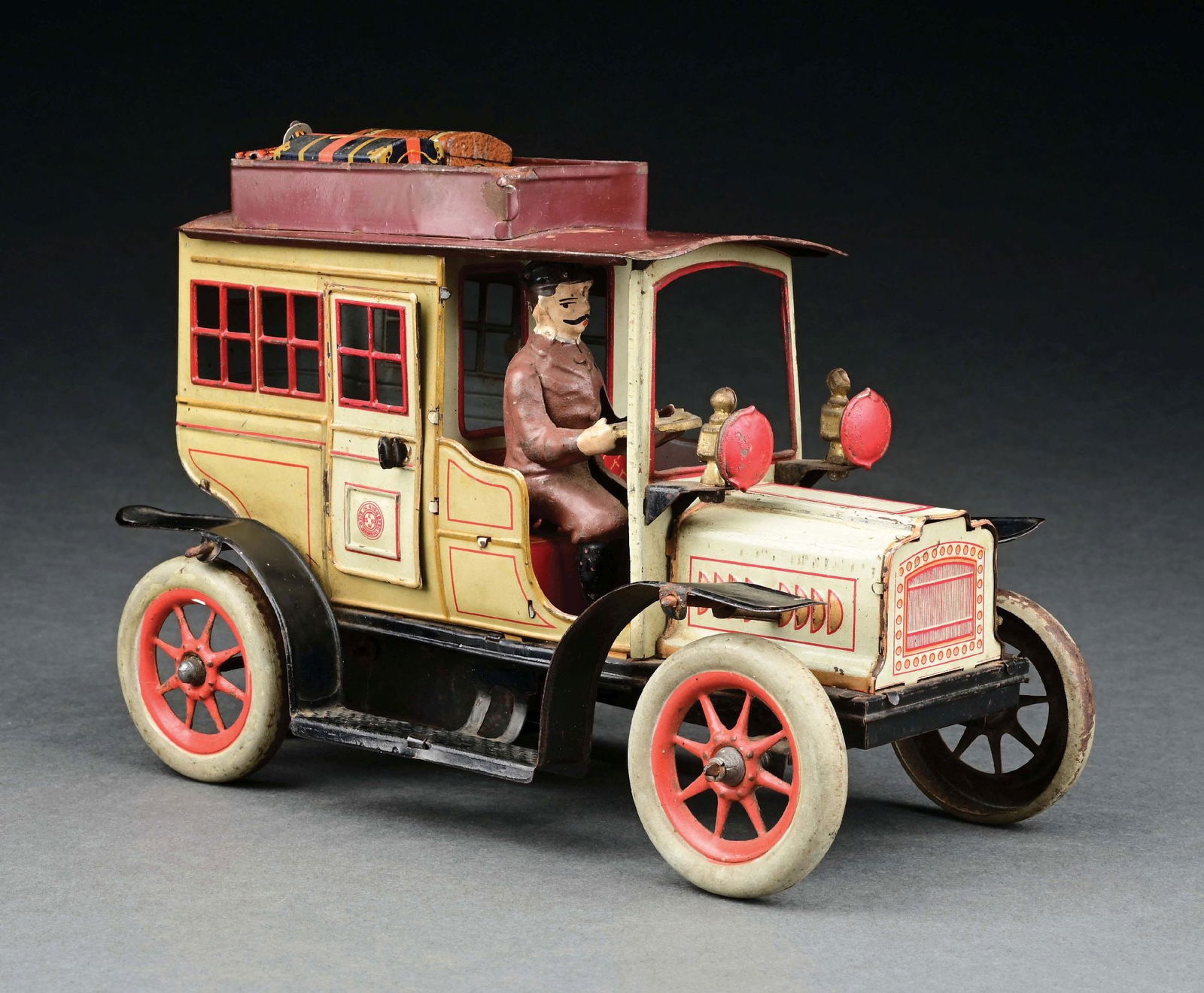 GUNTHERMANN TIN LITHO LIMOUSINE W/ HAND-PAINTED FIGURE: CONDITION: Original hand-painted driver in near mint condition, rest of the automobile is excellent condition. Includes three tin litho pieces of luggage. Item Dimensions: 8" x 4 - 1/2" x 6".