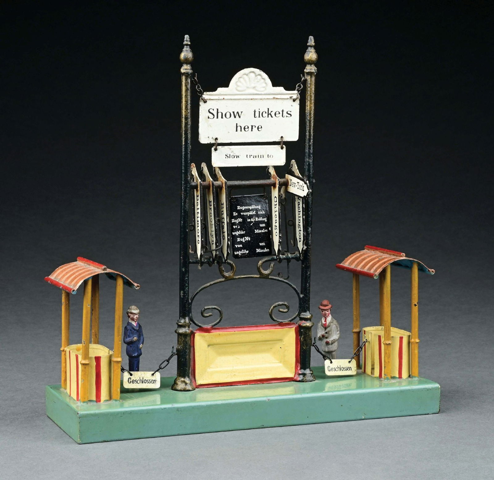 MARKLIN HAND PAINTED DESTINATION BOARD WITH TICKET COLLECTOR STAND: For US market. Black hanging sign and two ticket entry signs are replaced. Otherwise near mint condition with two original standing figures. Item Dimensions: 9 - 3/4" x 3 - 1/2" x 10".