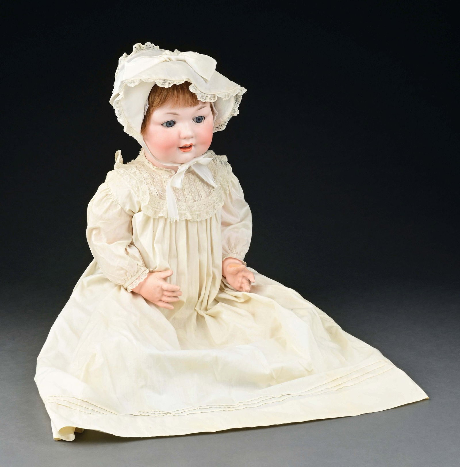 EXCEPTIONALLY LARGE GERMAN CHARACTER BABY: More than life-size doll with bisque socket head, open mouth with two lower teeth, blue glass sleep eyes, and incised on back of the head "Germany A. 15 M." The doll is on its original German composit