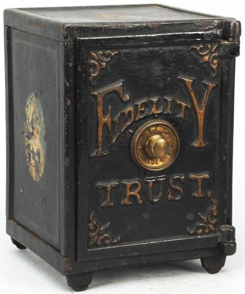 Cast Iron Fidelity Trust Safe Still Bank.: Painted black with bronze accents and decals on both sides. Marked “Made by Henry Hart Mfg Co. Detroit Michigan Pat May 12 1885” on bottom. Working two combination brass dial. Complete original wo