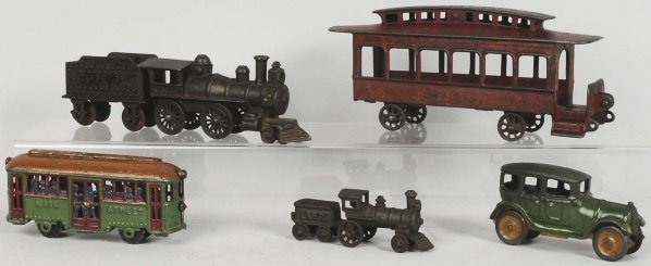 Lot of 6: Cast Iron Vehicle Toys.: Includes one engine, one tender, one combination engine and tender, and one Broadway Car Line trolley with missing horse and broken and missing stairs. Also includes re-cast Main Street Trolley bank t