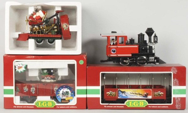 Lot of 4: LGB Train Items.: Contemporary. Includes Lake George steam engine and three Christmas related cars: 42215, 21020, and 32250. Includes three original boxes for the cars with some overall wear. Condition (Excellent).