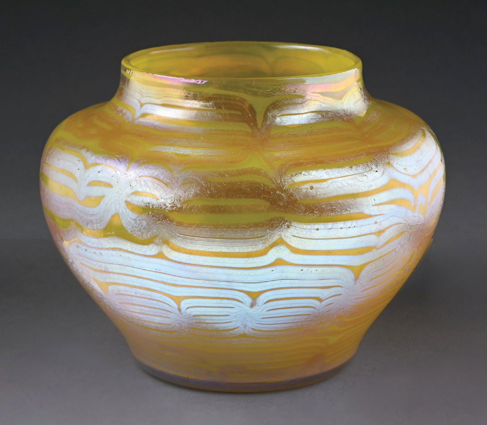LEMON YELLOW LOETZ JARDINIERE: C. 1900, PG 85/3780. A gorgeous glass vase by Loetz. The 5-1/2" tall vase has a diameter of approx. 7" at its widest. It is composed of yellow glass with a lovely swirling iridescent pattern throughou