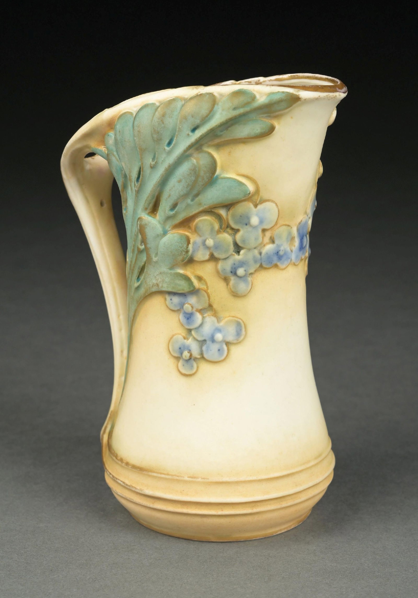PAUL DACHSEL FLORAL EWER: Stylized flowers with blue, green, and cream glazes. Crisp execution. Raised PD Medallion mark, "Made in Austria," impressed "103" and "4." Literature An example of the model is illustrated in Scott, 