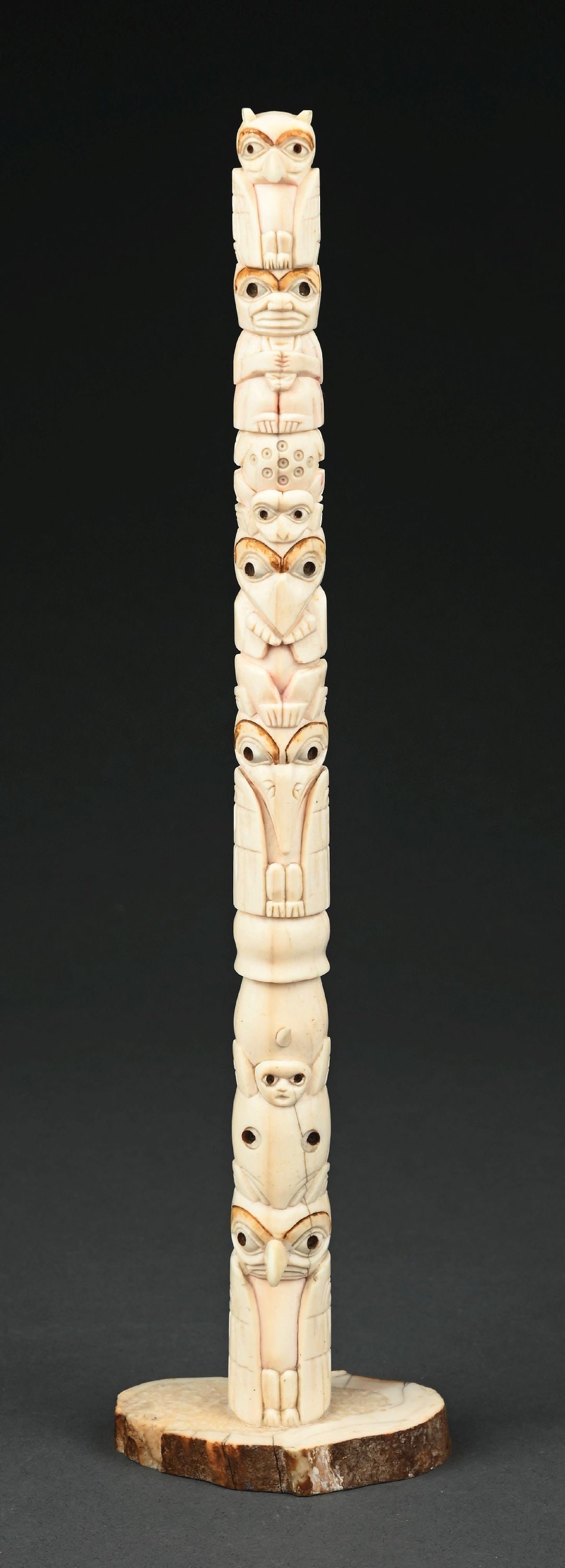 HAND CARVED NORTHWEST COAST TOTEM POLE: A fine hand-carved north west coast walrus tusk totem pole. Height measures 11-1/2". Condition: (Excellent). Dimensions: 11 - 1/4" T.
