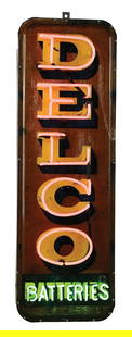 DELCO BATTERIES TIN SIGN W/ ADDED NEON: SST. Embossed Tin Sign for Delco Batteries showing added neon throughout the lettering. CONDITION: Neon is in excellent working order, and sign is mounted on a metal display can. Sign shows heavier we