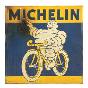 MICHELIN TIRES EMBOSSED TIN SIGN W/ BIBENDUM ON BICYCLE GRAPHIC.