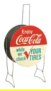 ENJOY COCA-COLA TIN TIRE HOLDER DISPLAY: DST. This c. 1960s double-sided tin tire display from Coca-Cola has a great color and shine, and displays wonderfully. CONDITION: Side 1 shows good gloss, with a few light surface scuffs and