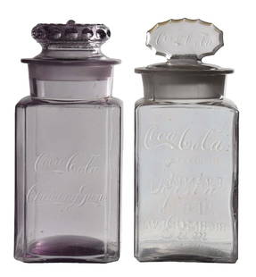 COLLECTION OF 2 COCA-COLA CHEWING GUM JARS: This collection of two c. 1910s glass chewing gum jars from Coca-Cola includes different versions reading "Coca-Cola Chewing Gum" and "Coca-Cola Pepsin Gum" with lid that reads "Coca-Cola". CONDITION: