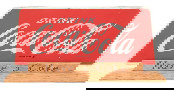 DRINK COCA-COLA GLASS COUNTER DISPLAY SIGN: This c. 1950s single-sided reverse glass sign from Coca-Cola features the iconic script logo with original wood base reading "Have a Coke". CONDITION: The glass sign shows light wear to the outer
