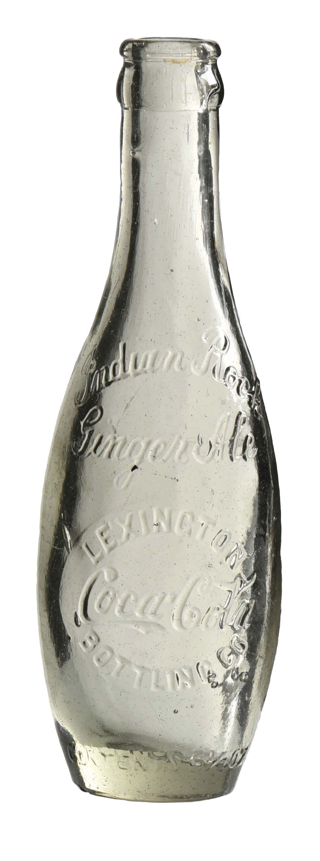 LEXINGTON BOTTLING CO. COCA-COLA BOTTLE: Clear Lexington, Kentucky Indian Rock Ginger Ale shoulder script with mid-body oval slug. CONDITION: Small fleabites at lip with minor chip. A great example. Condition: (8.5). Dimensions: 1 -1/2" D. x
