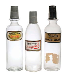 COLLECTION OF 3 SODA SYRUP BOTTLES WARD'S LEMON CRUSH, MILLER'S ORANGE ALE, & LEMON LIFE: C. 1920. Collection of 3 soda syrup bottles. (A) Label under glass "Lemon Life" showing light wear at the edges, no breaks or cracks with original lid. (B) Millers Orangeade label under glass bottle
