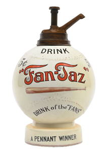 DRINK 5¢ "FAN-TAZ" BASEBALL SYRUP DISPENSER: This c. 1910s-1920s ceramic syrup dispenser from Fan Taz, the "Drink of the Fans," features the form of a baseball with an early bat graphic. CONDITION: The body of the dispenser shows yellowing to th