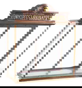 COUNTERTOP COUNTRY STORE SHOWCASE ADVERTISING ROWNTREE'S CHOCOLATES: C. 1920. CONDITION: It shows lifting to the top, with all original glass, backdoors and interior hardware. It shows a repair needed to the walnut framing. The top sign is in good reverse glass
