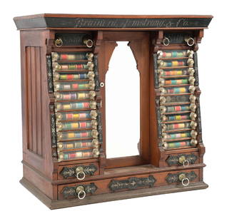 BRAINERD ARMSTRONG & CO. WALNUT THREAD CABINET: C. 1900. CONDITION: A wonderful walnut spool cabinet from the Brainerd Armstrong Co. It shows an original stenciled tule work to the front applied accents. It shows all original hardware, glass front