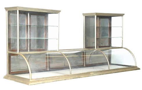 DOUBLE-STEEPLE FLAT-TOP CURVED GLASS COUNTRY STORE SHOWCASE: C. 1910. Marked "M. Anderson, Chicago". CONDITION: Showing all original glass with original rear doors. There are areas of dings and scrapes to the German metal. Applied interior shelves are present,