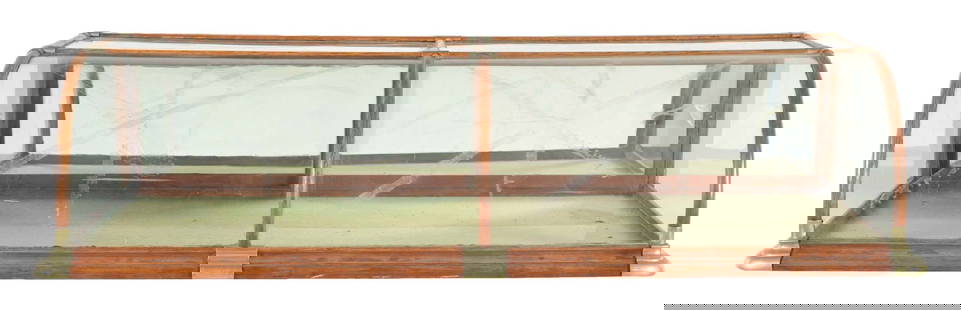 COUNTERTOP OAK FRAMED CURVED GLASS COUNTRY STORE SHOWCASE: C. 1915. Maker marked "The Lutke Manufacturing Co. Portland, Oregon and Seattle, Washington". CONDITION: An oak framed, curved glass showcase with original doors, brass corners and glass. It shows lig