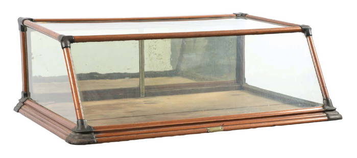 COUNTERTOP COUNTRY STORE SHOWCASE W/ SLANT FRONT & CAST IRON CORNERS: C. 1915. Maker marked for the Parley & Hofman Co. out of Rochester, New York. CONDITION: It shows all original glass with original mirrored backdoors, showing some oxidation to the mirrors. All