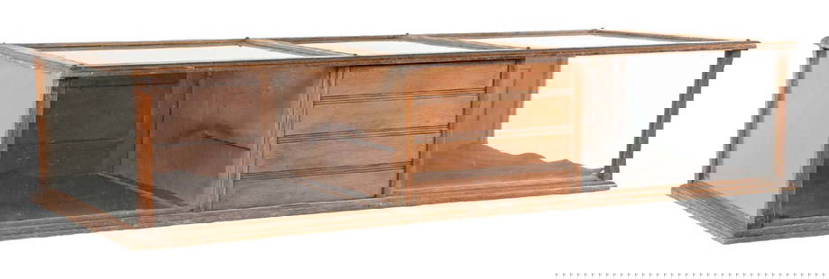 COUNTRY STORE COUNTERTOP SHOWCASE: C. 1910. CONDITION: It shows oak construction with two display compartments, cashbox and top drawer. It shows areas of wear and finish loss. A repair needed to one of the bottom panels, as well as a g