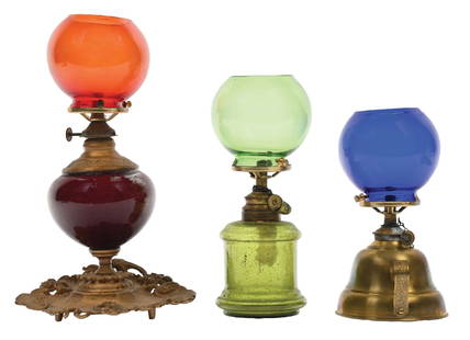 COLLECTION OF 3 COUNTERTOP CIGAR LIGHTERS: C. 1900. CONDITION: (A) A glass font cigar lighter with green globe. (B) A brass-base cigar lighter with blue globe. (C) A red font cigar lighter with ash tray and red globe. All show no chips,