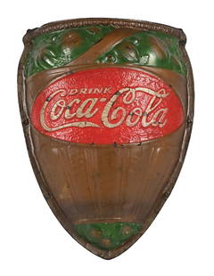 COCA-COLA WALL SCONCE SIGN: This c. 1930s paper-mache wall sconce sign from Coca-Cola features the script logo and nice embossed features throughout. CONDITION: The field shows paint loss, with general crackling to the painted s
