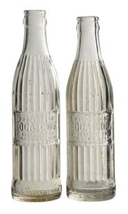 COLLECTION OF 2 COCA-COLA BOTTLES: (A) Clear Lincoln, Nebraska straight-sided ribbed body with mid-body rectangular slug marked "PROPERTY OF COCA-COLA BOTTLING CO. / MIN. CONT. 7 FL. OZ.". Some staining. (8.5). (B) Clear Key West, Flor