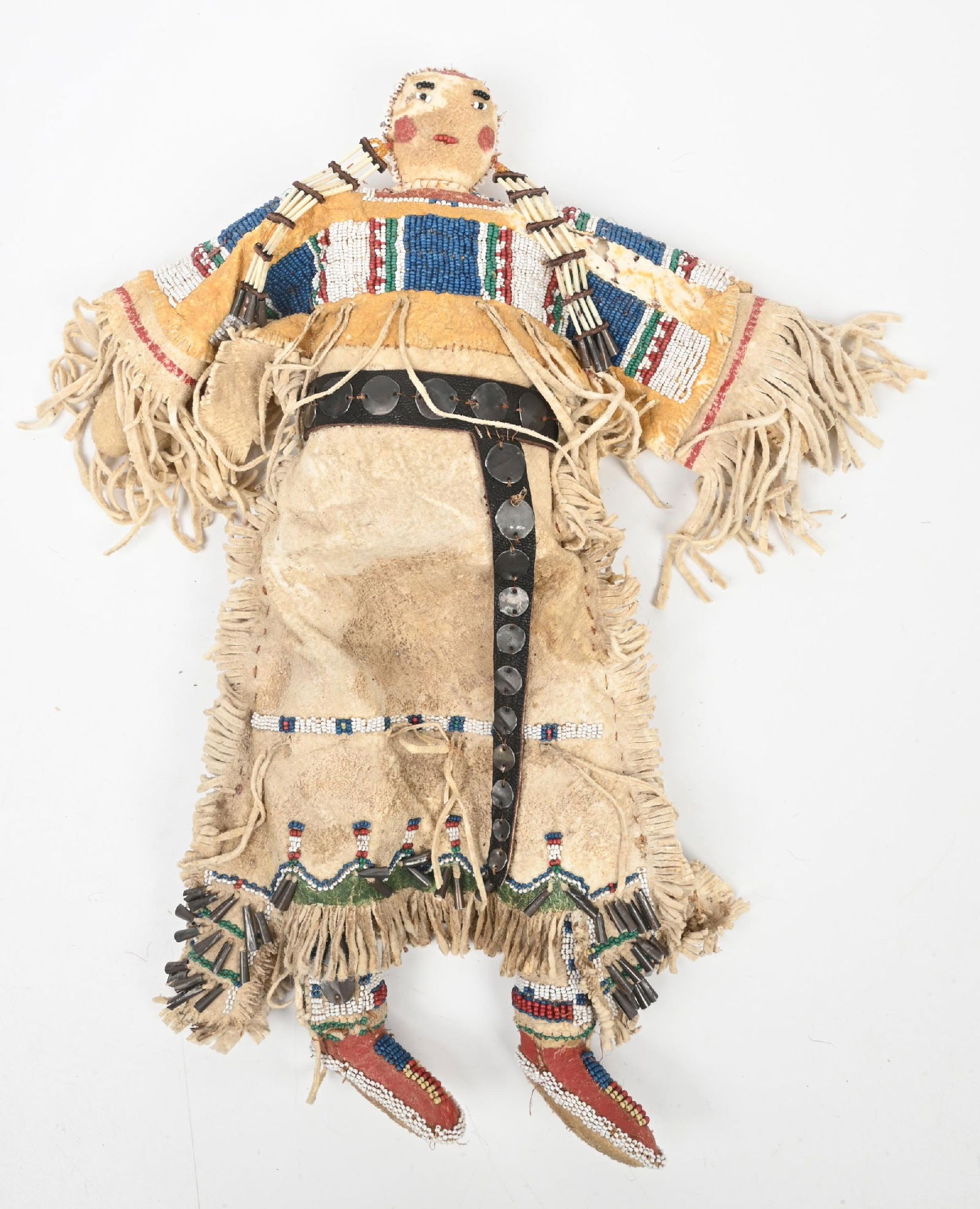 SOUTHERN PLAINS BEADED DOLL: Cheyenne beaded doll with fringed buckskin dress. Rubbed in yellow ochre with stained green highlights. Great details with tiny dentalium necklace and concho belt. Circa 1880s. 15" tall. CONDITION: Ve