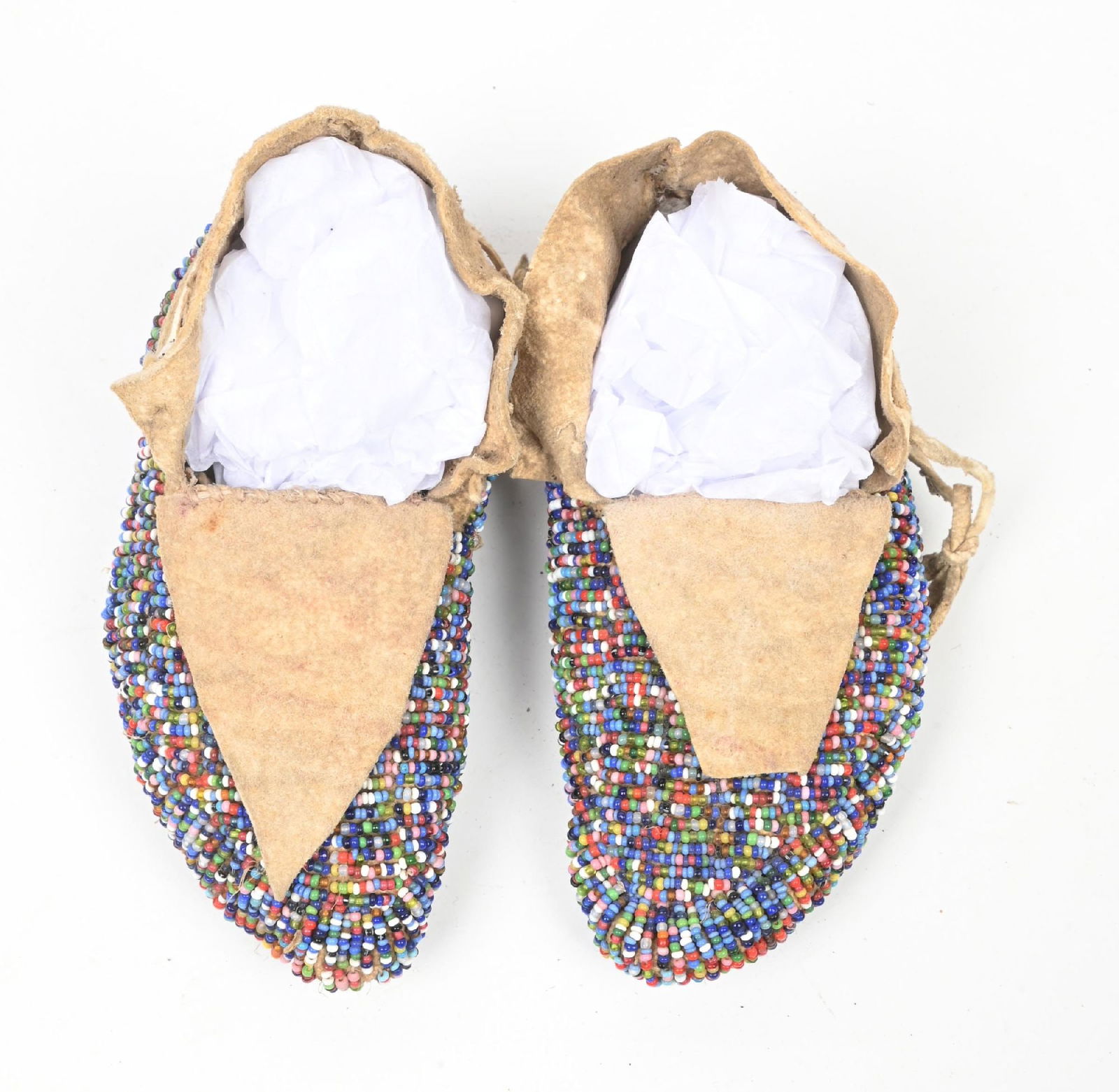 CHILDS' BEADED MOCCASINS: Fully beaded child's moccasins finished top and bottom in "salt and pepper" multi-colored beads. Circa 1890-1920. CONDITION: Very good. Dimensions: 5 1/2" L.