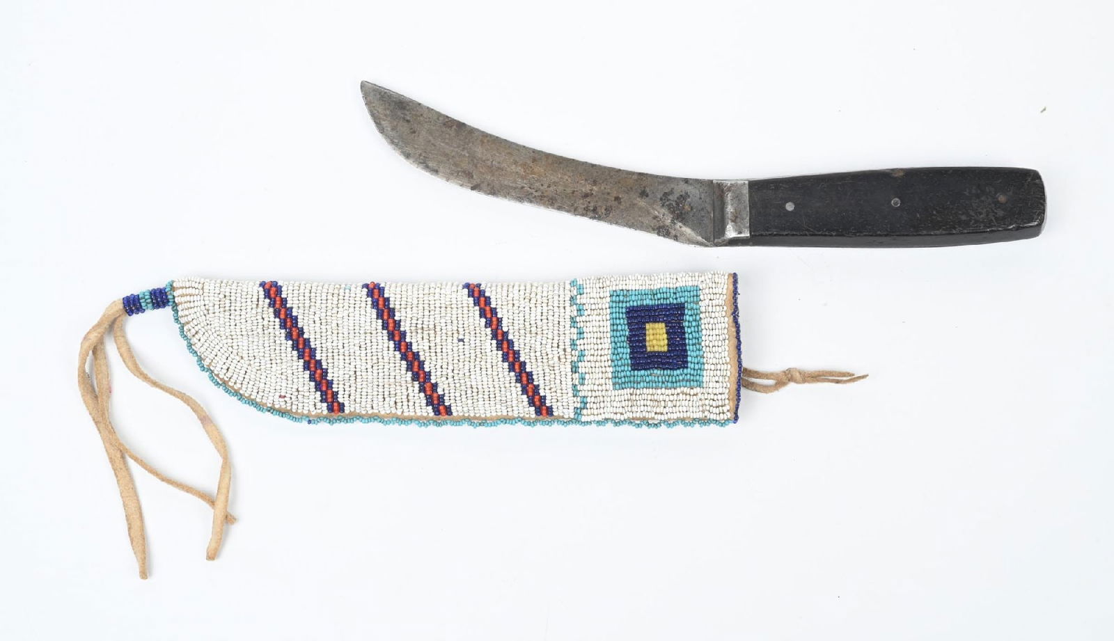 CHEYENNE BEADED KNIFE SHEATH: Double sided with geometric patterns of greasy yellow, light blue, red, and translucent blue on a white field. 8" in length. Included is a period skinning knife with a pewter bolster. CONDITION: Very