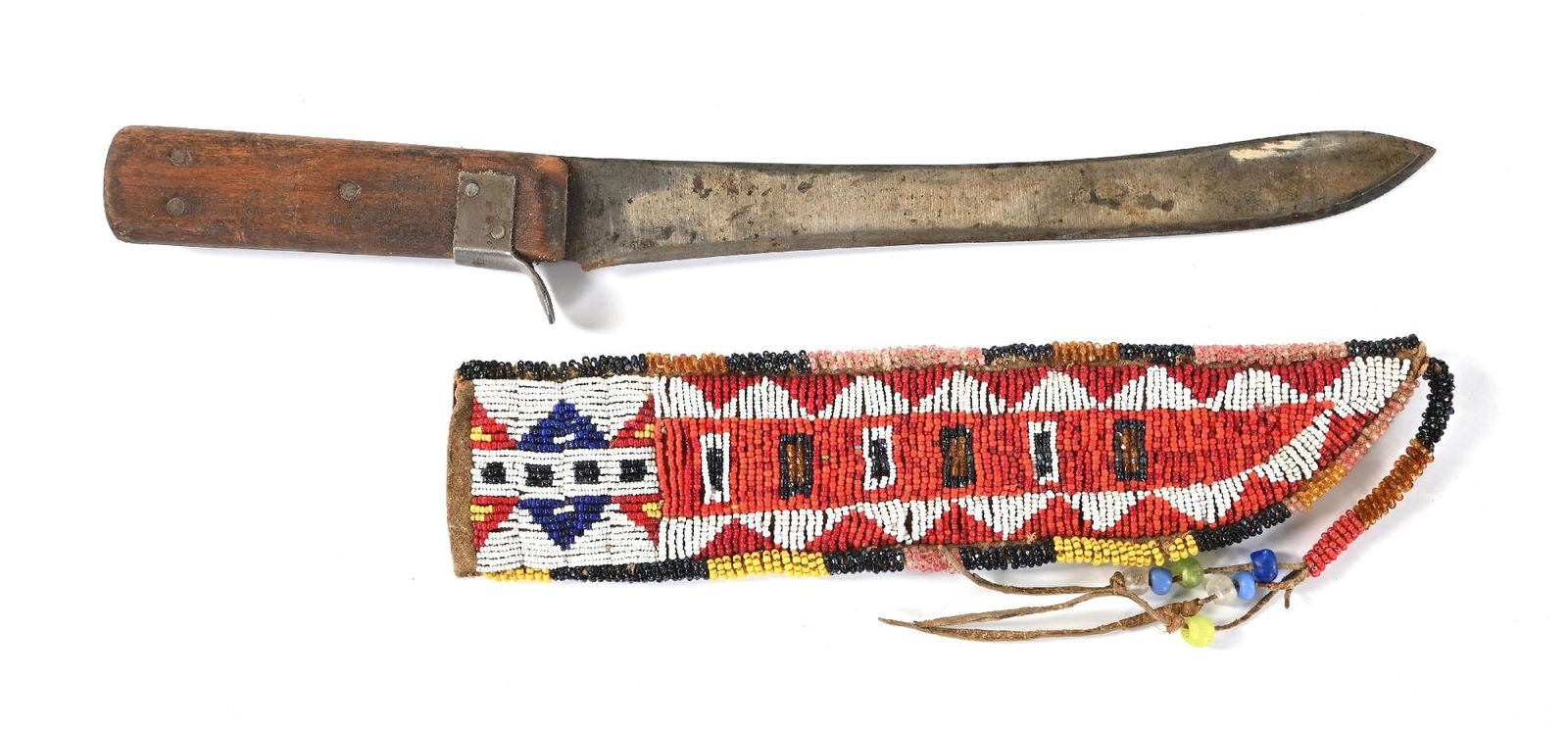 RED, BLACK, & WHITE BEADED KNIFE SHEATH: Plains beaded knife case finished on native tanned buckskin with rawhide back. Includes older skinning knife. Circa 1920-1940. 10 1/2" L. CONDITION: Very good. Dimensions: 10 1/2" L