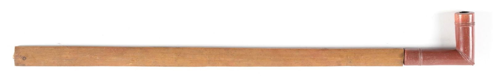 PLAINS CATLINITE PIPE: Simple style elbow shaped catlinite bowl with hardwood stem. 23 1/2" length. CONDITION: Very good. Dimensions: 23 1/2" L.