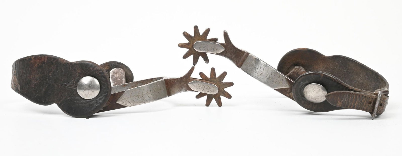 TEXAS STYLE SPURS: Crockett spurs with silver overlaid pattern and vintage leather straps. 2 1/2" Band x 2" Shank x 1 1/2" Rowels. CONDITION: Very good. Dimensions: 8" x 5"