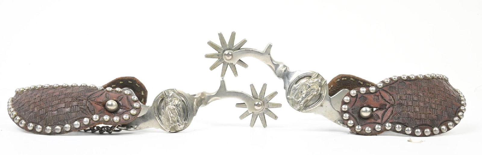 AUGUST BUERMANN NICKELED HORSE HEAD SPURS: Maker stamped with classic Buermann star on heel bands with nickel studded straps. 1 1/2" band x 2 1/4" shanks x 1 5/8" rowels. CONDITION: Excellent. Dimensions: 10" x 4 1/4" x 2".